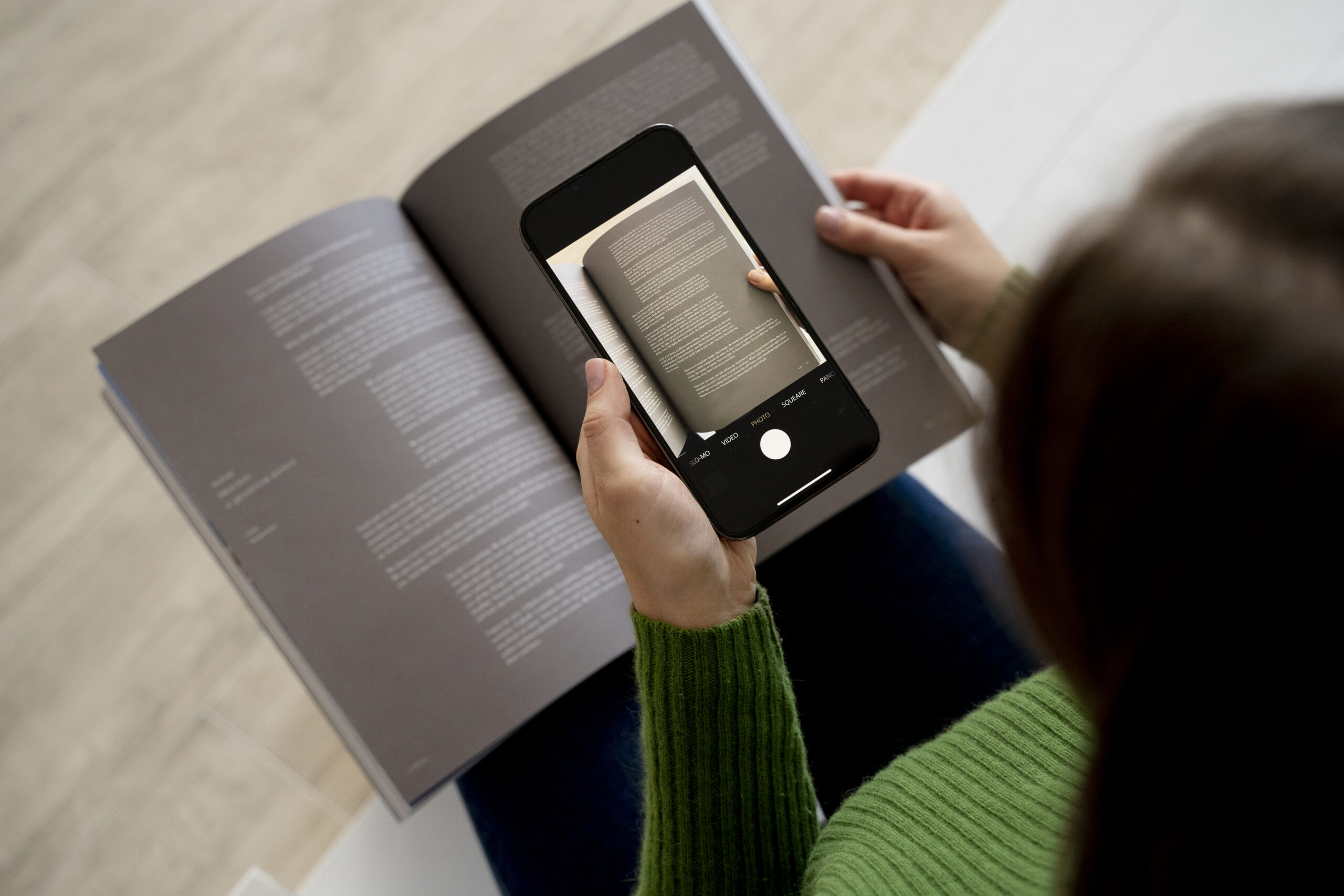 woman-taking-pictures-of-a-magazine-using-her-smartphone